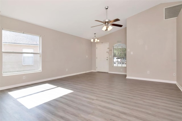 8561 Deer Chase Dr, Riverview, FL 33578 - unfurnished living room featuring wood finished floors, ceiling fan with notable chandelier, visible vents, baseboards, and vaulted ceiling