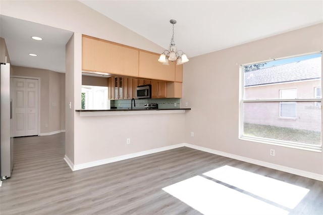 8561 Deer Chase Dr, Riverview, FL 33578 - kitchen with wood finished floors, dark countertops, pendant lighting, a notable chandelier, and stainless steel microwave