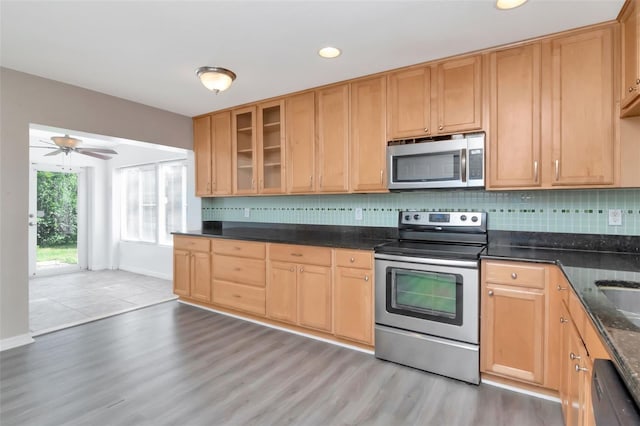 8561 Deer Chase Dr, Riverview, FL 33578 - kitchen featuring light wood-style floors, backsplash, glass insert cabinets, and appliances with stainless steel finishes
