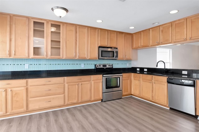 8561 Deer Chase Dr, Riverview, FL 33578 - kitchen featuring a sink, stainless steel appliances, glass insert cabinets, light brown cabinets, and light wood-style floors
