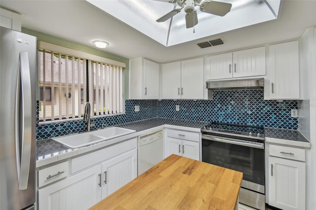 kitchen with exhaust hood, a sink, stainless steel appliances, backsplash, and visible vents