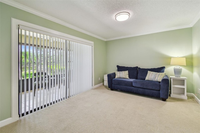 carpeted living area with a textured ceiling, baseboards, and ornamental molding
