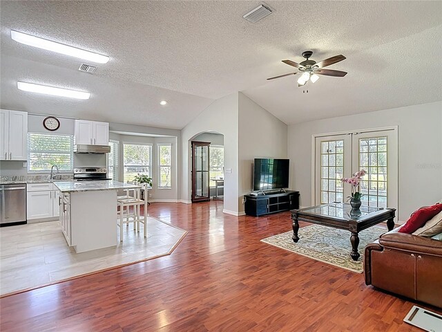 19227 Garden Quilt Cir, Lutz, FL 33558 - living room with visible vents, arched walkways, and a textured ceiling