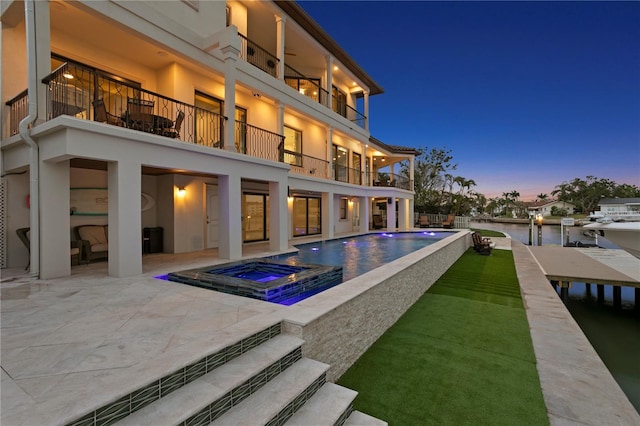 5939 Bayview Cir S, Gulfport, FL 33707 - back of property with an in ground hot tub, a patio area, an infinity pool, a balcony, and stucco siding