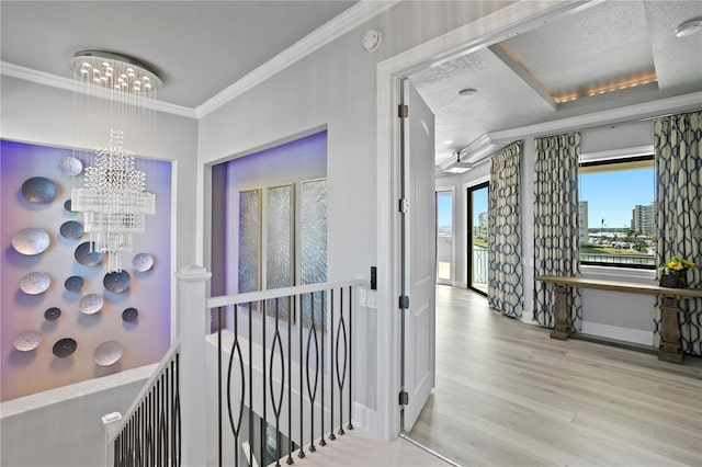 5939 Bayview Cir S, Gulfport, FL 33707 - hallway with crown molding, a notable chandelier, wood finished floors, baseboards, and an upstairs landing