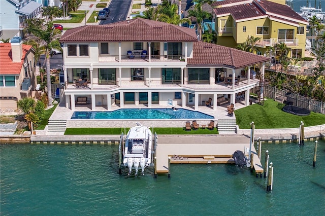 5939 Bayview Cir S, Gulfport, FL 33707 - back of property featuring boat lift, a fenced backyard, a balcony, a patio, and a tiled roof