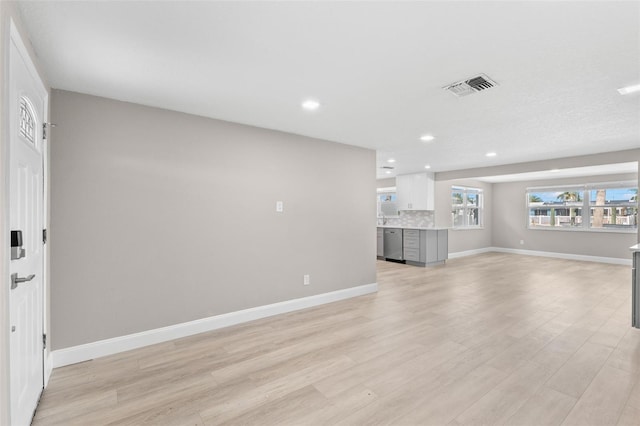 13704 Evelane Dr, Hudson, FL 34667 - unfurnished living room featuring light wood finished floors, baseboards, and recessed lighting