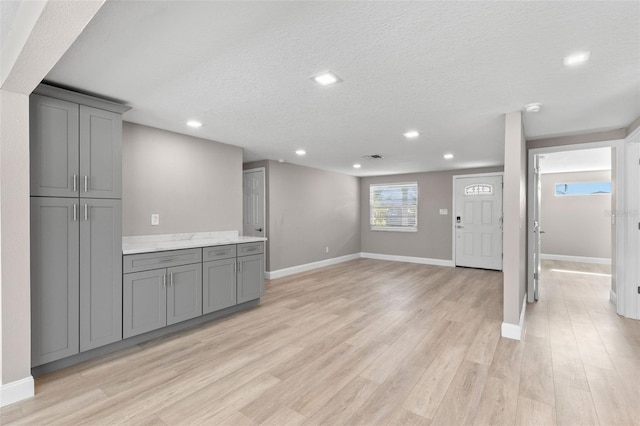 13704 Evelane Dr, Hudson, FL 34667 - unfurnished living room featuring light wood-style flooring, recessed lighting, a textured ceiling, and baseboards