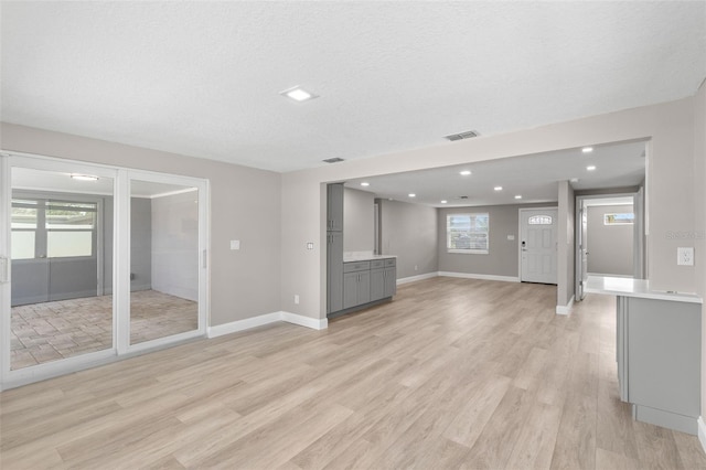 13704 Evelane Dr, Hudson, FL 34667 - unfurnished living room featuring healthy amount of natural light, light wood-style floors, recessed lighting, and baseboards