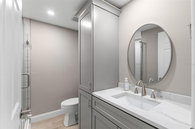 13704 Evelane Dr, Hudson, FL 34667 - full bath with toilet, wood finished floors, an enclosed shower, and vanity