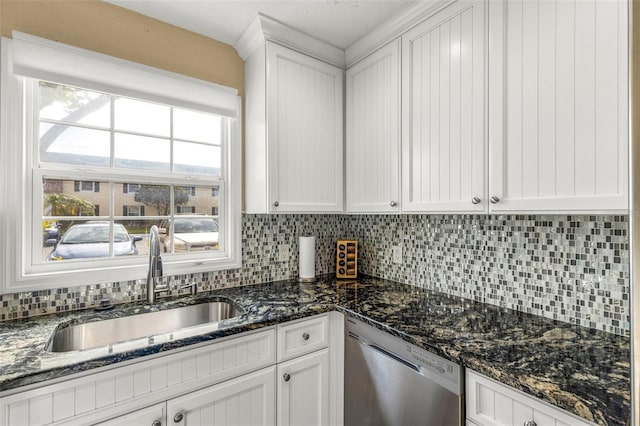 kitchen with stainless steel dishwasher, backsplash, white cabinetry, and a sink