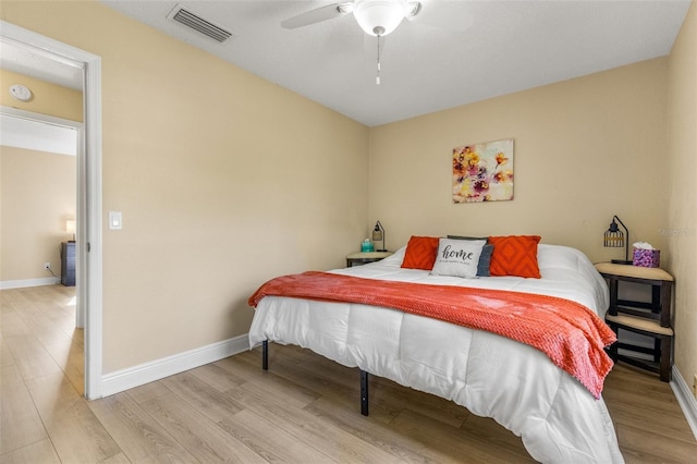 bedroom with ceiling fan, baseboards, visible vents, and wood finished floors