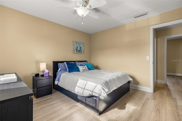 bedroom featuring baseboards, ceiling fan, light wood finished floors, and visible vents