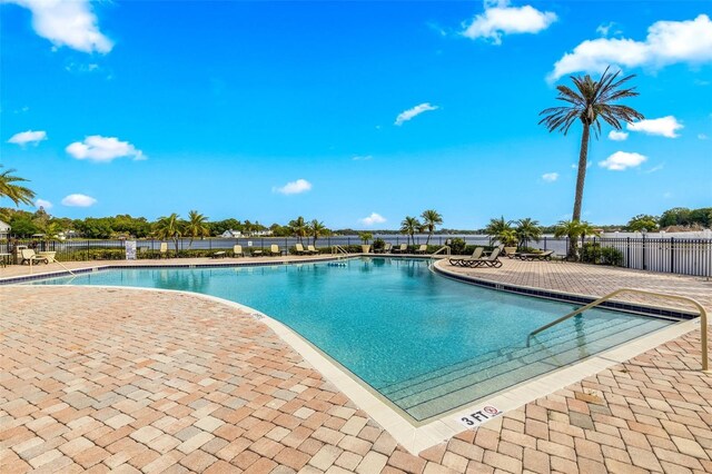 community pool featuring fence and a patio area