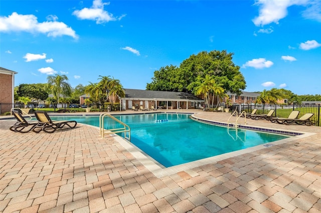 community pool with fence and a patio area