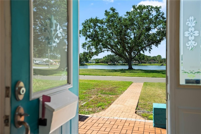 entryway featuring a water view and brick patterned floor