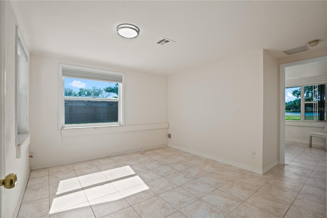 unfurnished room featuring baseboards, light tile patterned flooring, and visible vents