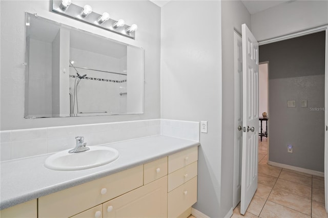 full bathroom with vanity, tile patterned flooring, baseboards, and a shower