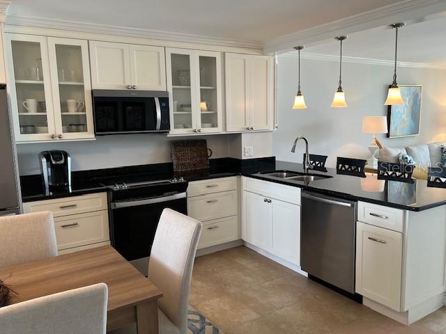 18304 Gulf Blvd Unit 309, Redington Shores, FL 33708 - kitchen with appliances with stainless steel finishes, a peninsula, a sink, crown molding, and pendant lighting