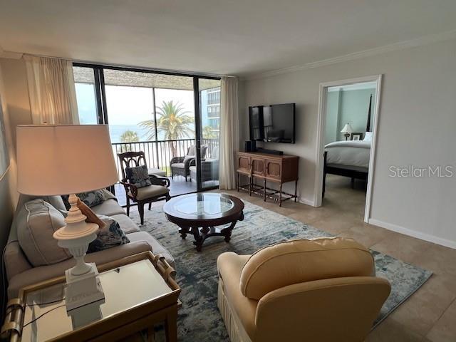 18304 Gulf Blvd Unit 309, Redington Shores, FL 33708 - living room with crown molding, baseboards, and expansive windows
