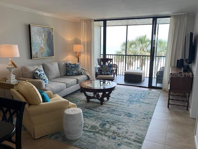 18304 Gulf Blvd Unit 309, Redington Shores, FL 33708 - tiled living area with crown molding, plenty of natural light, and expansive windows