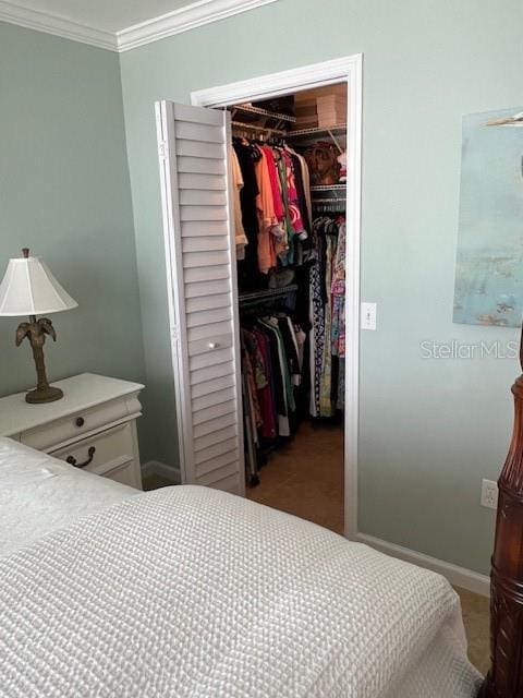 18304 Gulf Blvd Unit 309, Redington Shores, FL 33708 - bedroom featuring a walk in closet, a closet, ornamental molding, and baseboards