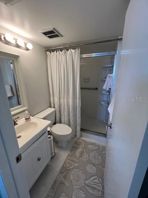 18304 Gulf Blvd Unit 309, Redington Shores, FL 33708 - bathroom featuring a stall shower, vanity, and toilet