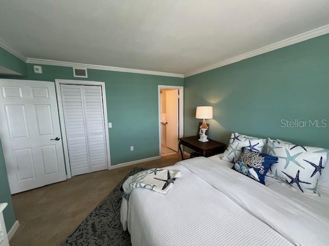 18304 Gulf Blvd Unit 309, Redington Shores, FL 33708 - carpeted bedroom with ornamental molding, a closet, and baseboards