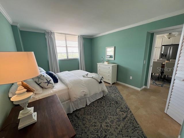 18304 Gulf Blvd Unit 309, Redington Shores, FL 33708 - bedroom with ornamental molding, baseboards, and stainless steel fridge