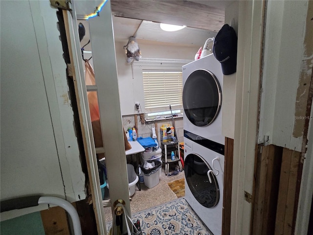 clothes washing area featuring laundry area and stacked washer and clothes dryer