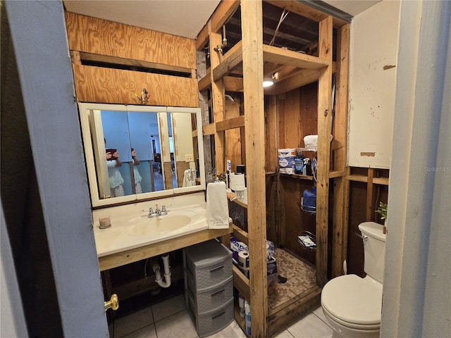bathroom with toilet, tile patterned floors, and a sink