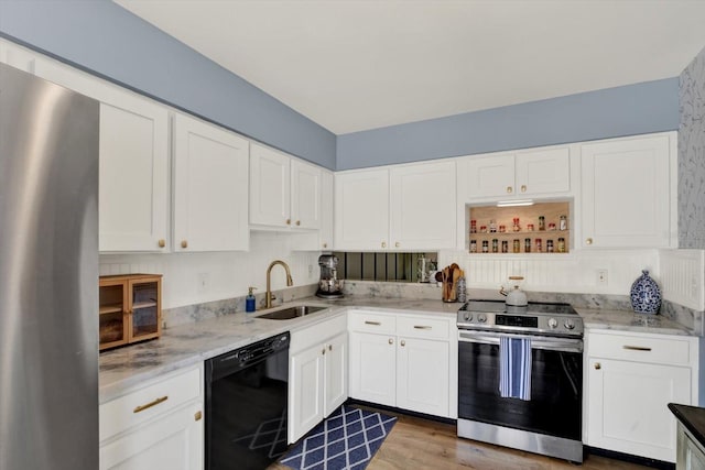 kitchen featuring a sink, white cabinetry, appliances with stainless steel finishes, and light stone countertops