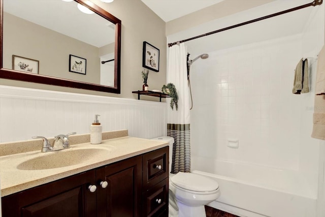 full bathroom with vanity, shower / tub combo with curtain, a wainscoted wall, and toilet