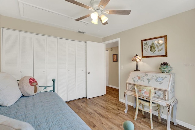 bedroom featuring visible vents, a closet, light wood-style floors, baseboards, and a ceiling fan