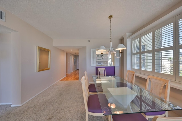 7882 Sailboat Key Blvd S Unit 401, South Pasadena, FL 33707 - dining space with an inviting chandelier, visible vents, baseboards, a textured ceiling, and carpet flooring