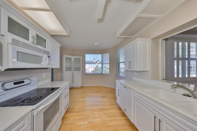 7882 Sailboat Key Blvd S Unit 401, South Pasadena, FL 33707 - kitchen with light countertops, white cabinetry, light wood finished floors, and white appliances