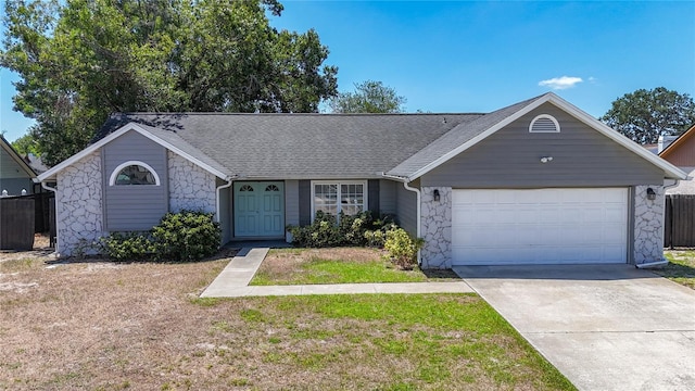 1005 Cameo Crest Ln, Valrico, FL 33596 - view of front of house with stone siding, driveway, a garage, roof with shingles, and a front lawn