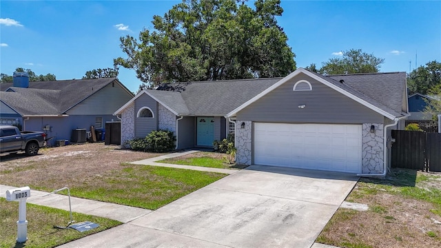 1005 Cameo Crest Ln, Valrico, FL 33596 - single story home featuring stone siding, an attached garage, driveway, fence, and central air condition unit