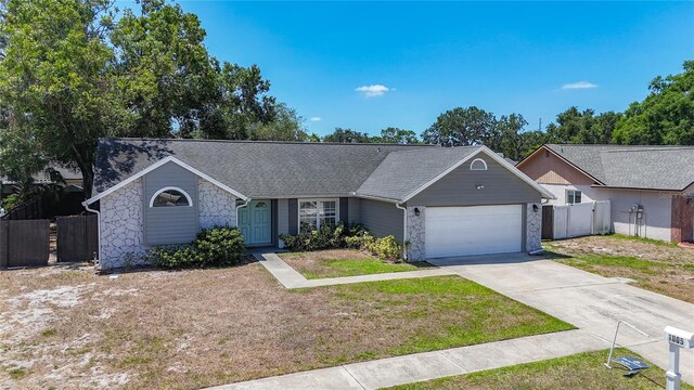 1005 Cameo Crest Ln, Valrico, FL 33596 - single story home with stone siding, an attached garage, concrete driveway, and a shingled roof