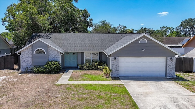 1005 Cameo Crest Ln, Valrico, FL 33596 - ranch-style house featuring stone siding, driveway, an attached garage, fence, and roof with shingles