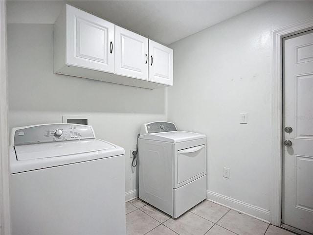 1005 Cameo Crest Ln, Valrico, FL 33596 - laundry area featuring independent washer and dryer, cabinet space, light tile patterned floors, and baseboards