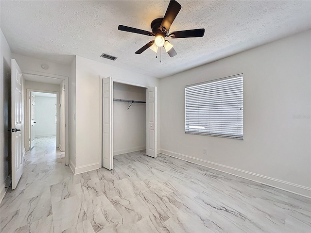 1005 Cameo Crest Ln, Valrico, FL 33596 - unfurnished bedroom featuring a textured ceiling, a closet, light marble finish flooring, a ceiling fan, and baseboards