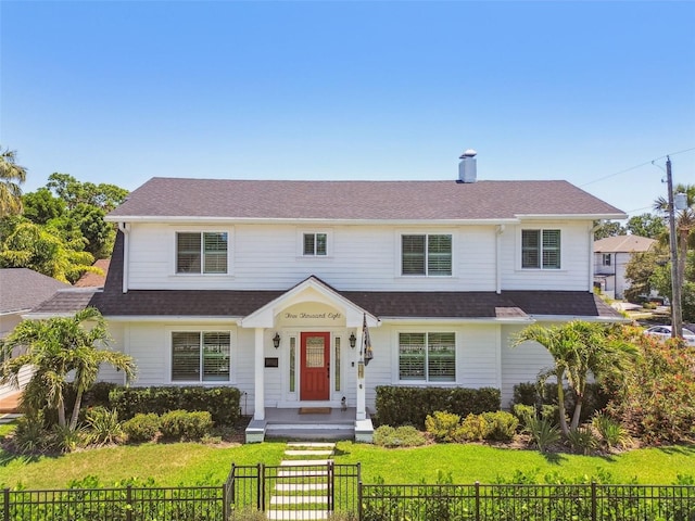 view of front of property featuring roof with shingles, a fenced front yard, and a front yard