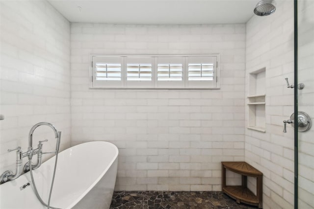 full bath featuring a freestanding tub and a tile shower