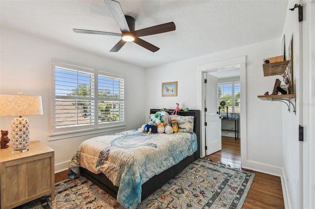 bedroom with baseboards, ceiling fan, and wood finished floors