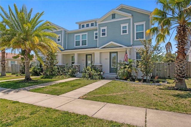 view of front of house featuring fence, a porch, and a front yard
