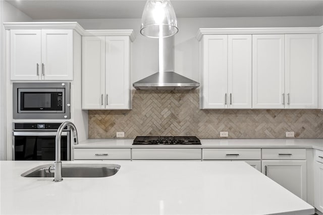 kitchen with backsplash, appliances with stainless steel finishes, a sink, light countertops, and white cabinetry