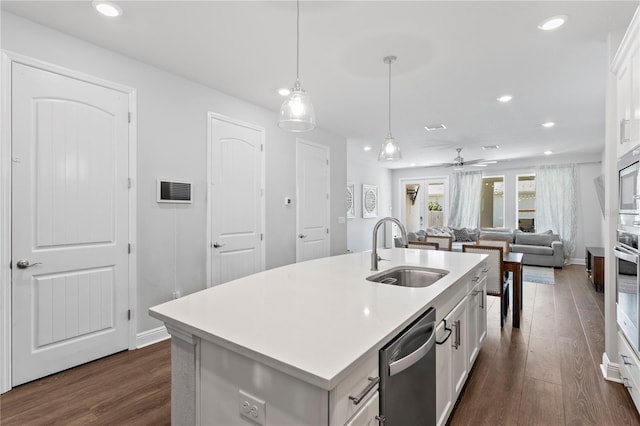 kitchen featuring white cabinets, a sink, light countertops, dark wood finished floors, and stainless steel appliances