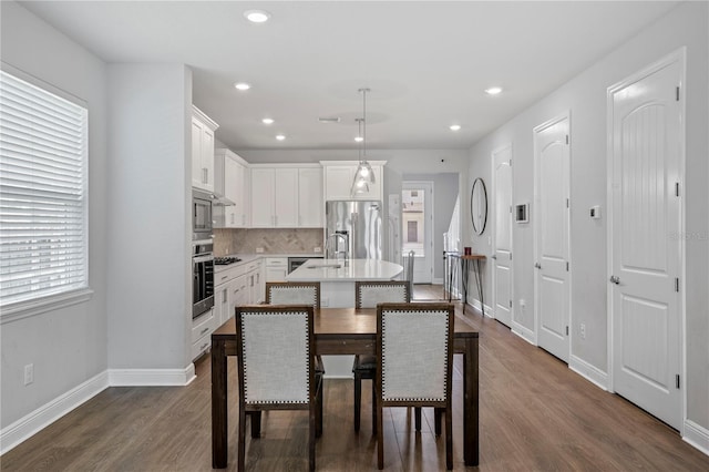 kitchen featuring recessed lighting, a sink, dark wood finished floors, appliances with stainless steel finishes, and backsplash