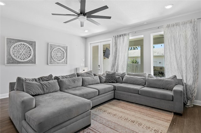 living room featuring dark wood-type flooring, a ceiling fan, baseboards, and recessed lighting
